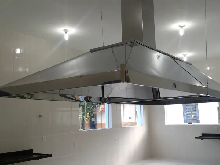 Coifa industrial em inox suspensa em cozinha profissional