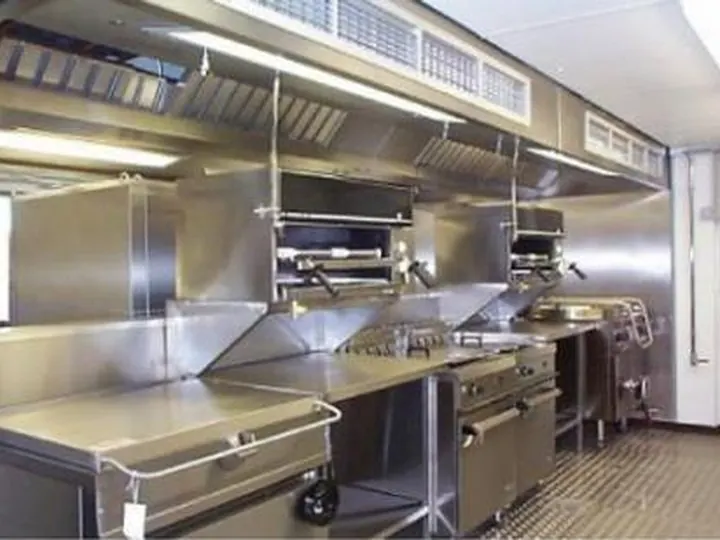 Cozinha profissional com bancadas e equipamentos em inox