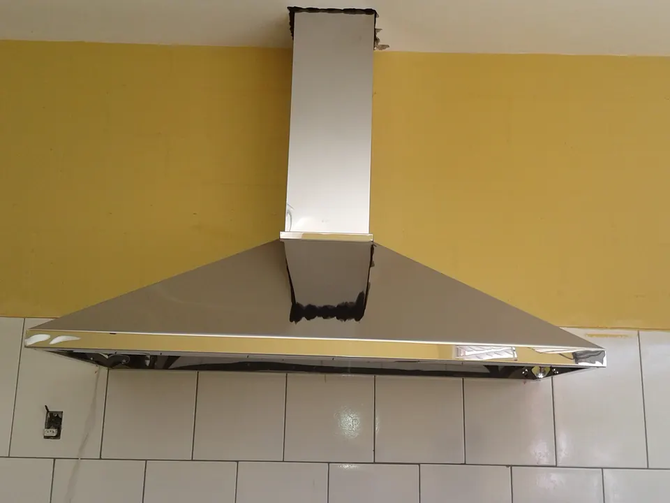Coifa industrial em inox instalada em cozinha