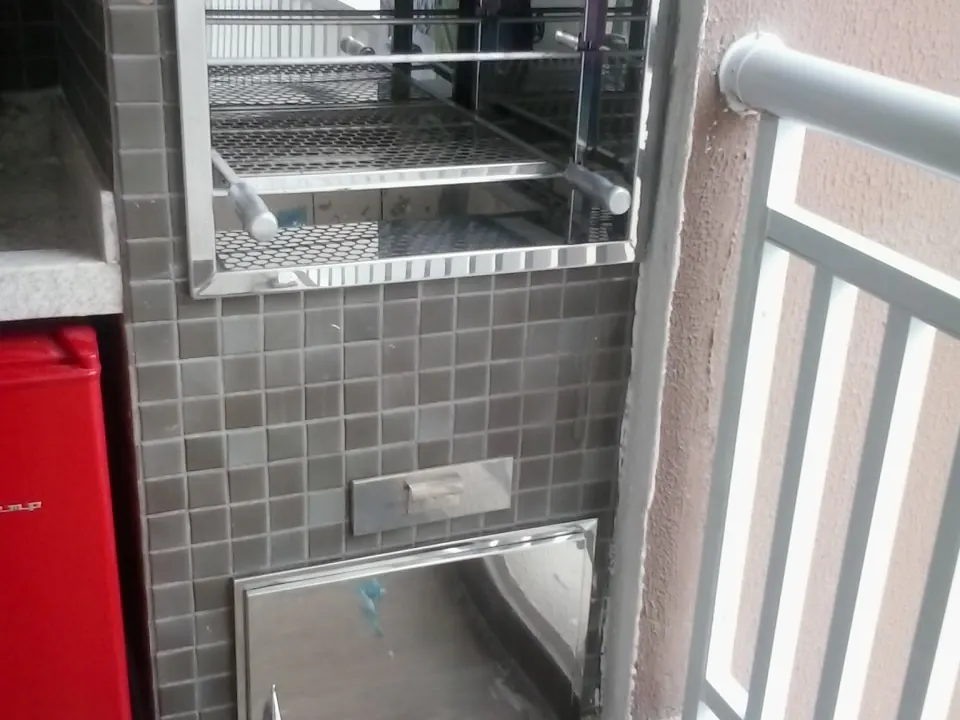 Churrasqueira de varanda com moldura e portas em inox